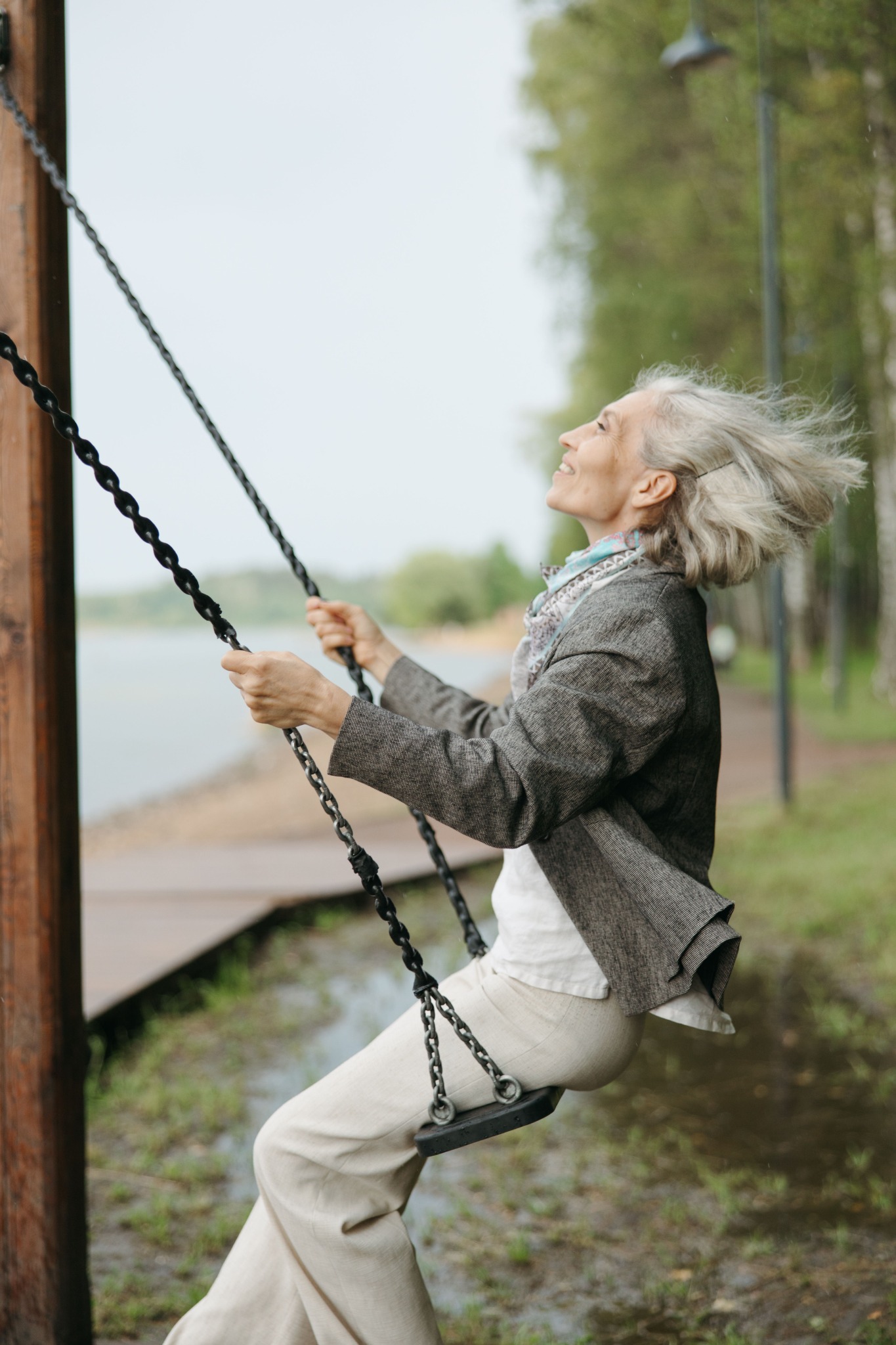 An older woman enjoying time outdoors on a swing